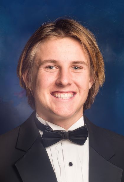 vance islander graduation photo on dark blue background. he has tousled blond hair and a wide smile